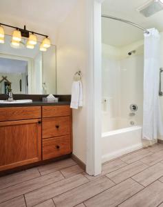 天使营世誉天使营酒店的带浴缸、水槽和镜子的浴室
