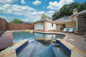 普莱诺Ultimate Comfort Design Pool & Sun in Plano TX的一个带甲板和房子的游泳池