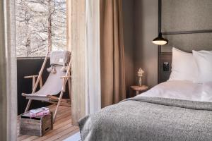 采尔马特Nomad by CERVO Mountain Resort的卧室配有床、椅子和窗户。