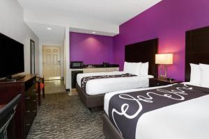 坦帕La Quinta by Wyndham Tampa Bay Area-Tampa South的酒店客房设有两张床和紫色墙壁。