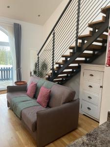 罗森代尔Rossendale Holiday Cottages的客厅设有一张沙发,设有楼梯