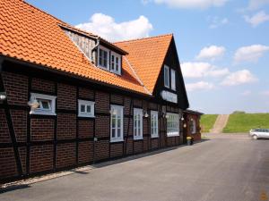 DamnatzHotel Steinhagen的一座拥有橙色屋顶和白色窗户的建筑