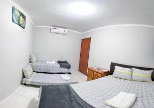 大坎普Apto com churrasq em Monte Castelo-Campo Grande MS的一间卧室设有两张床和床头柜。