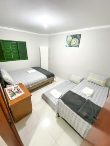 大坎普Apto com churrasq em Monte Castelo-Campo Grande MS的一间设有两张床和一张桌子的房间