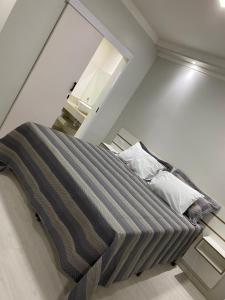 蓬塔波朗GUARANY HOTEL PONTA PORÃ的一张床上,床上有条纹毯子,放在房间里