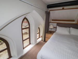 雷文格拉斯Old School Muncaster House的一间卧室设有一张床和两个窗户。