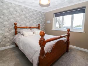 霍利黑德Cedars的一间卧室设有一张床和一个窗口