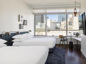 圣地亚哥Kimpton Alma San Diego, an IHG Hotel的一间卧室设有两张床和大窗户