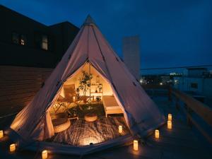 荒尾Noasobi Lodge 206- Vacation STAY 45777v的屋顶上的一个金字塔帐篷,晚上有灯