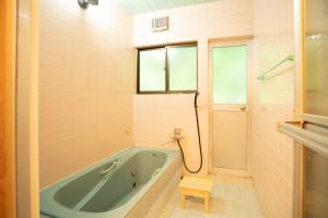 壹岐市I,K,I HOUSE TSURUKIFURE - Vacation STAY 14773v的带浴缸的浴室和窗户。