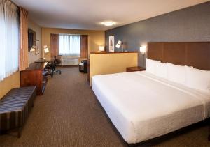 波特兰Silver Cloud Hotel - Portland的酒店客房设有一张大床和一张书桌。