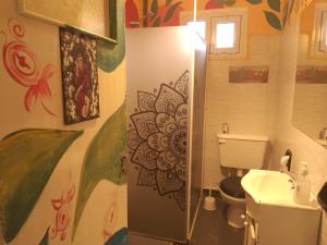 埃博森Hostel "La Casita Naranja"的浴室设有卫生间和水槽,墙上挂有绘画作品