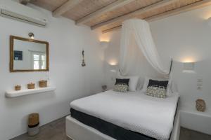 阿波罗尼亚Venia's Guesthouse的白色卧室配有床和镜子
