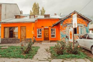 埃博森Hostel "La Casita Naranja"的一座橙色房子的侧面涂有涂鸦