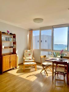 普拉亚布兰卡Sounds of The Sea Apartment的客厅配有桌椅和窗户。