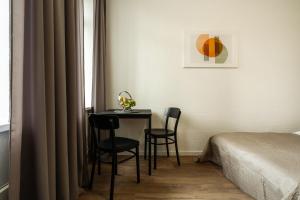 维尔纽斯Air Apartment 202的一间在床边配有桌子和两把椅子的房间