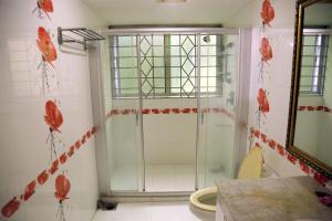 达卡Ali International Hotel的墙上设有红色鲜花淋浴的浴室