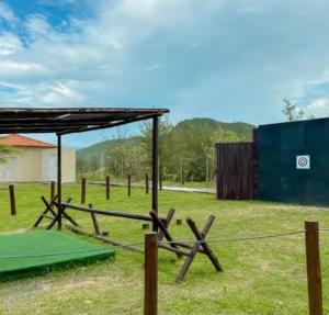 布希奥斯Hotel Búzios Resort com Entretenimento的一个带木栅栏和棚子的田野