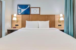 泰勒泰勒大学区驻桥套房酒店的一张大白色的床,位于酒店客房内
