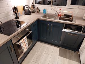 多尼戈尔AMY'S Place Charming 3 Bed House Donegal的厨房配有蓝色橱柜和水槽