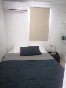 卡塔赫纳Hermoso Apartaestudio, privado, acogedor, super aseado, excelente ubicación!的一间卧室配有一张带蓝色毯子的床