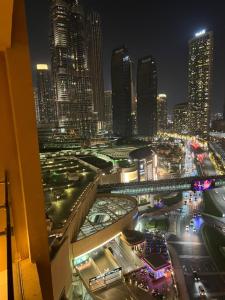 迪拜Address Dubai Mall Residences New name EMAAR Residences Fashion Avenue 1 bedroom 34 floor的享有夜间城市景观和建筑