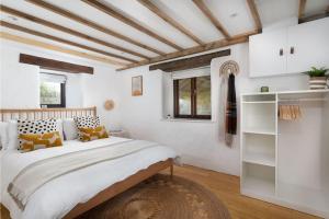 彭赞斯Cosy cottage, walk to Porthcurno beach, Pedn Vouder, Minack & PK Museum的一间卧室设有一张大床和白色的墙壁