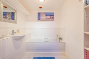 KentLocation, Location, Location with King Size Bed的白色的浴室设有浴缸和水槽。