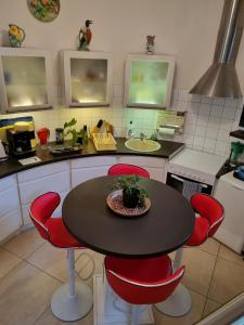 滨海圣帕莱Moulin Vieux的厨房配有桌子和红色椅子