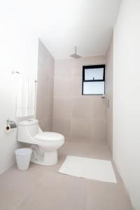QuesadaHotel Ventura的白色的浴室设有卫生间和窗户。
