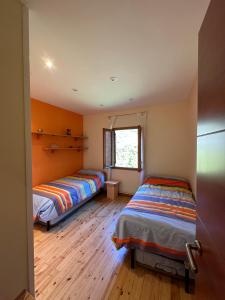 里亚尔普Piso Rialp con vistas的铺有木地板的客房内的两张床