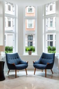 伦敦Radisson Blu Edwardian Kenilworth Hotel, London的带窗户的客房内的2把蓝色椅子
