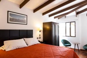 库斯科Hostal & Apartments El Triunfo的一间卧室配有一张橙色大床和两把椅子