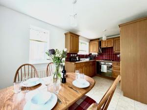 比斯特Comfortable 3 bedroomed house in Bicester的厨房配有带盘子和鲜花的木桌