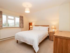 谢伯恩Lanes End的卧室设有一张白色大床和一扇窗户。