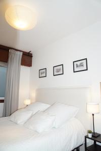 拉科鲁尼亚Amazing Location CORUÑA DOWNTOWN的卧室内的白色床和白色枕头