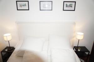 拉科鲁尼亚Amazing Location CORUÑA DOWNTOWN的卧室配有带两盏灯的白色床