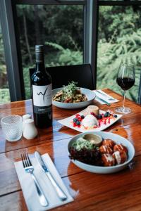 BeechmontBinna Burra Sky Lodges的一张桌子,上面放着两盘食物和一瓶葡萄酒