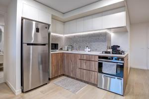 堪培拉The Hamptons - Lux 2 Bed 2 Bath, Pool - Central Location的厨房配有不锈钢冰箱和木制橱柜
