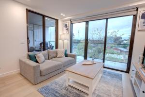 堪培拉The Hamptons - Lux 2 Bed 2 Bath, Pool - Central Location的客厅配有沙发和桌子