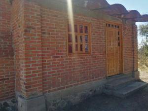 Tlaxco de MorelosCABAÑAS TLAXCO LA LOMA的砖砌的建筑,有门和窗户