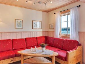 布雷克斯塔德6 person holiday home in Brekstad的客厅里一张红色的沙发,配有桌子