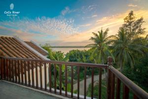 会安会安河可可度假酒店的阳台享有水景和棕榈树美景。