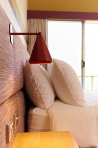 堪培拉政治家酒店 的床上的红色灯和枕头
