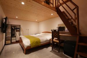大溪Lemuju樂木居河岸行館的一间卧室配有一张床、一张书桌和一个楼梯