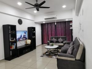 实兆远Coco HomeStay 旅人の家@The Venus Sitiawan Perak的客厅配有两张沙发和一台电视机
