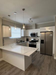 Saint HelenaSHAK Condos- Luxury, Functionality and Comfort的厨房配有白色台面和冰箱