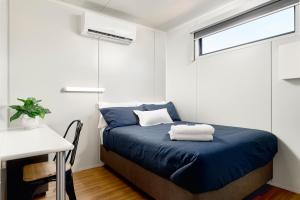 纽曼Red Sands Accommodation Newman的一间卧室配有一张床、一张书桌和一个窗户。