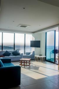 曼塔Departamento Suite frente al mar Poseidon Manta的客厅配有蓝色的家具和玻璃窗。