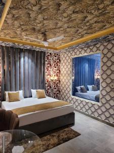 巴雷利Bellazio Suites Hotel & Resort的卧室配有一张床,墙上配有电视。